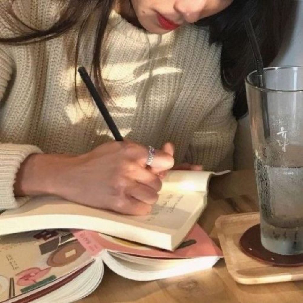 girl writing in cafe
