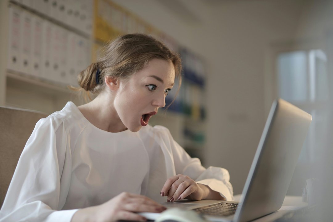 A shocked woman looking at something on her laptop | Source: Pexels