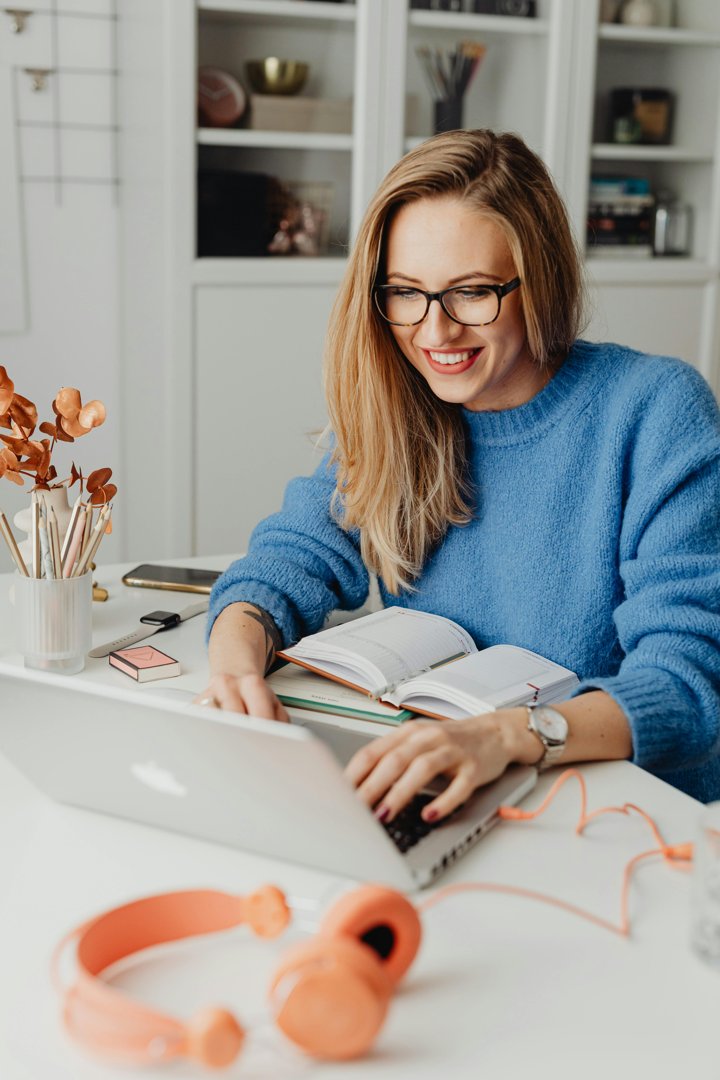 A happy woman working on a laptop | Source: Pexels