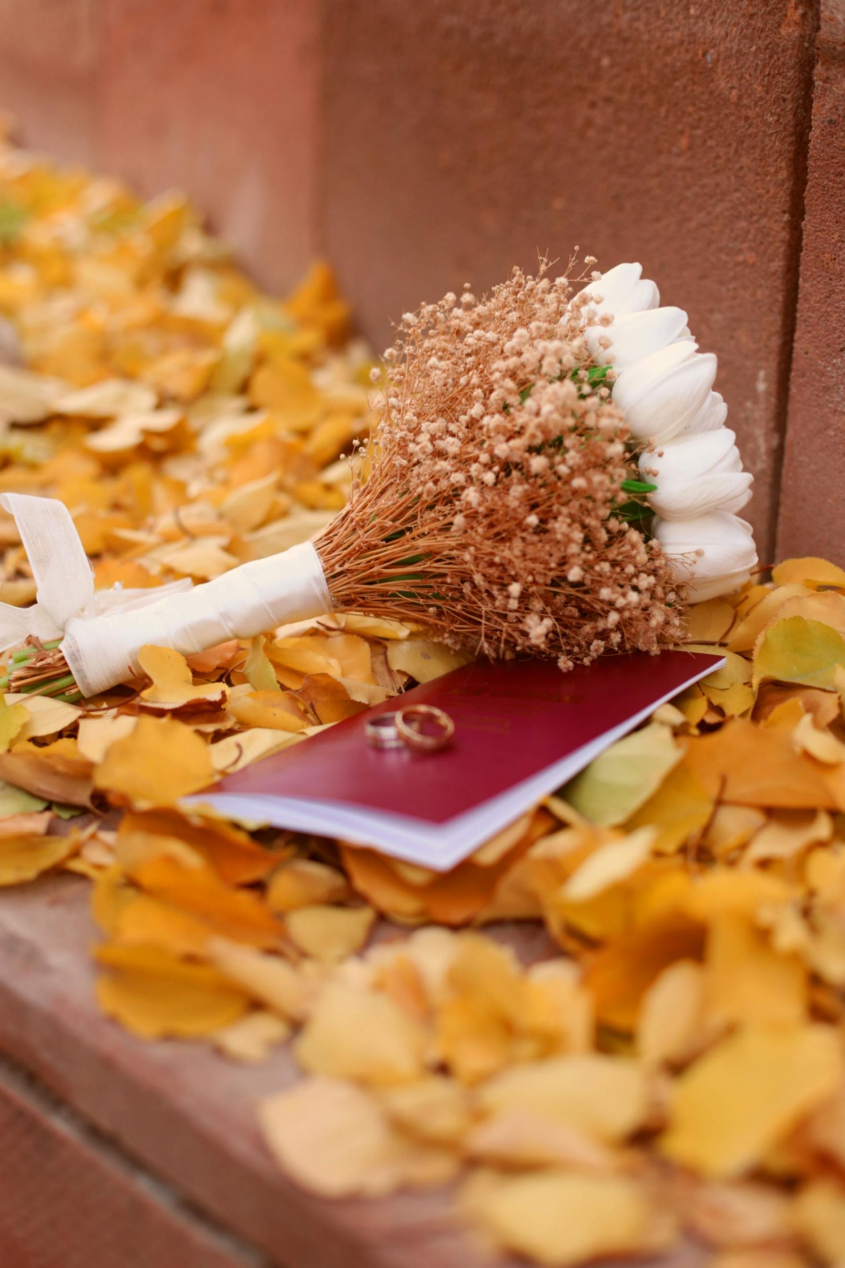 A wedding bouquet with rings lying on autumn leaves | Source: Pexels