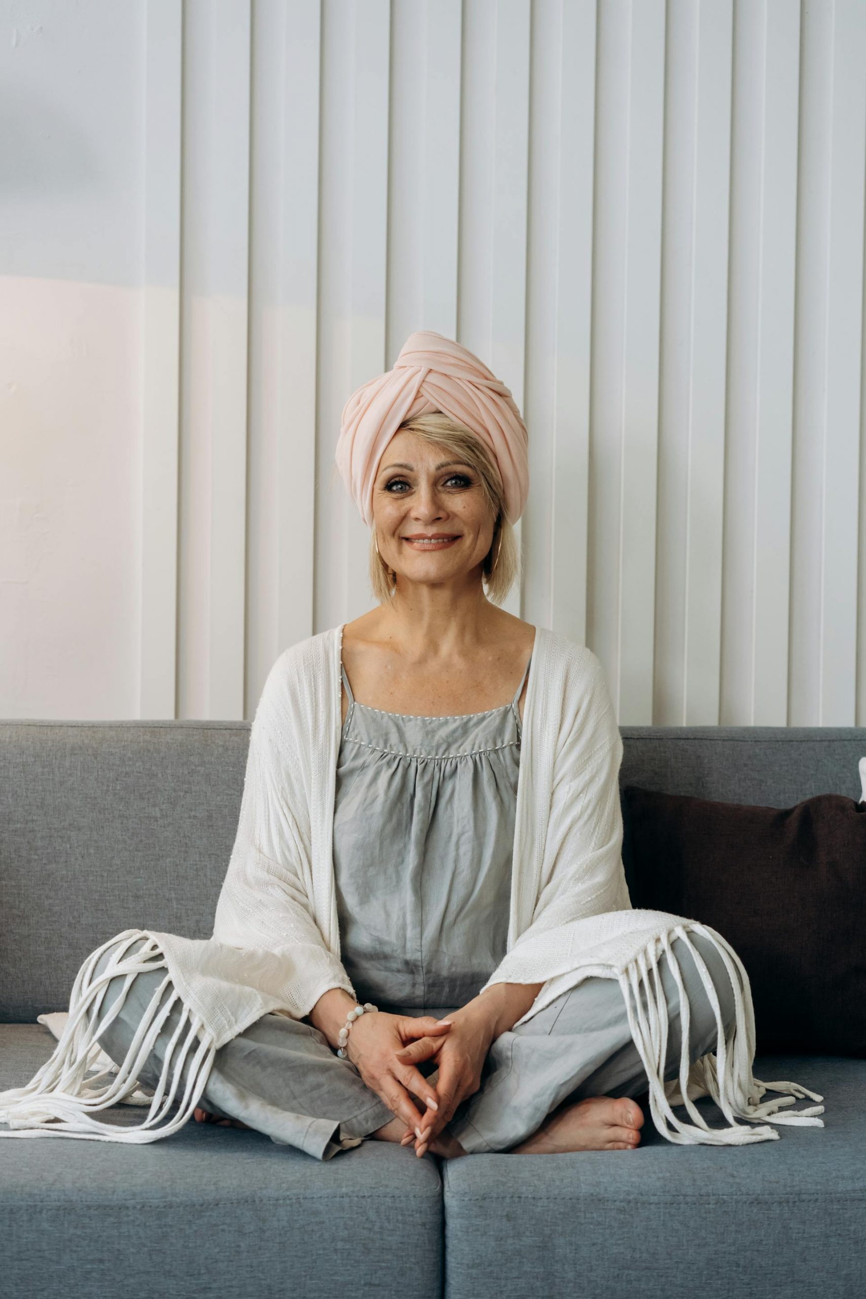 A smiling woman sitting on a sofa | Source: Pexels