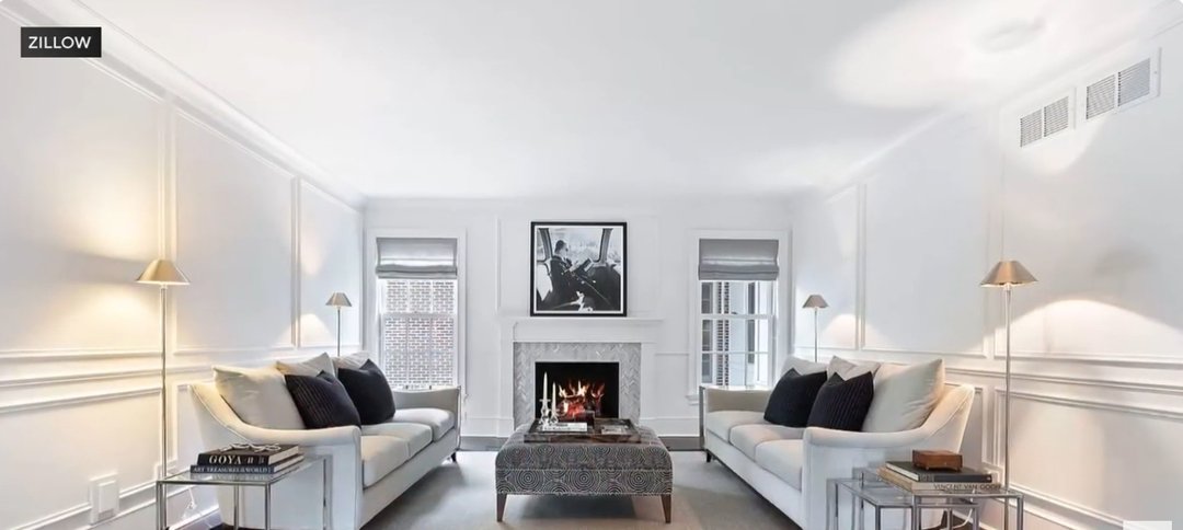 The “Home Alone” fireplace has been reimagined into a chic, modern focal point framed by crisp white walls and minimalist décor. Twin sofas and metallic accents create a balanced, elegant symmetry. The space glows with warmth and sophistication, blending contemporary style with timeless comfort. | Source: YouTube/CBSChicago