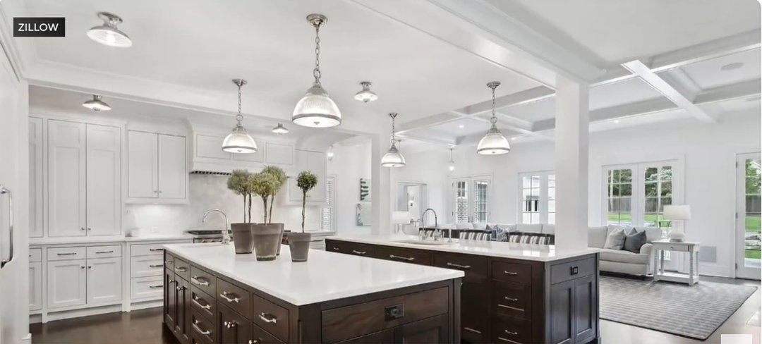 The famous “Home Alone” kitchen now features a bright, open-concept design with sleek white cabinetry and contrasting dark wood islands. Modern pendant lights add a touch of elegance, while natural light pours in from wide windows. The space exudes sophistication and warmth, blending luxury with family comfort. | Source: YouTube/CBSChicago