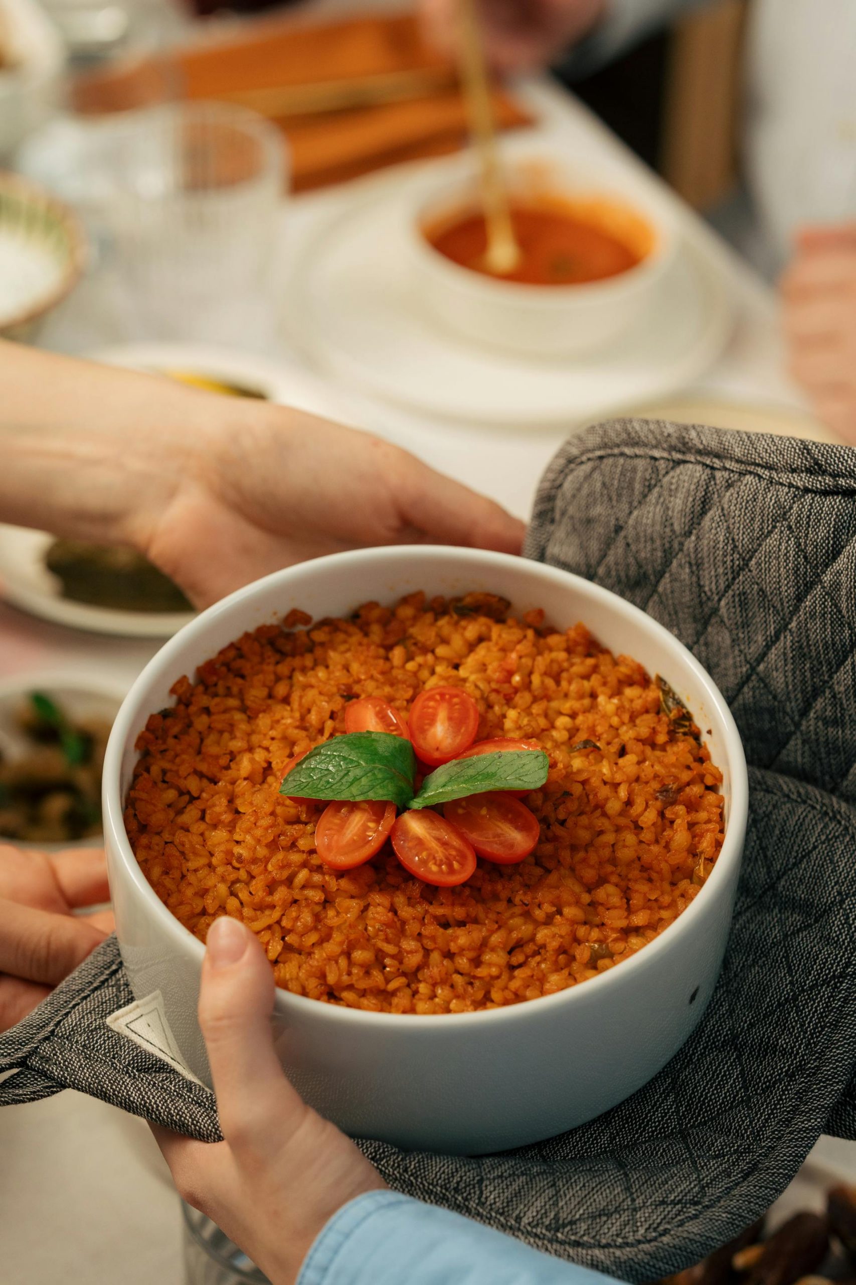 Two hands holding a bowl of tomato pilaf | Source: Pexels