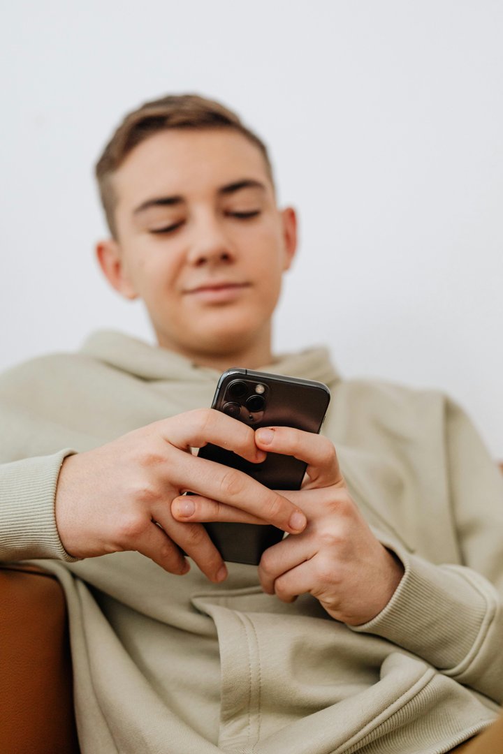 A teenage boy using his phone | Source: Pexels