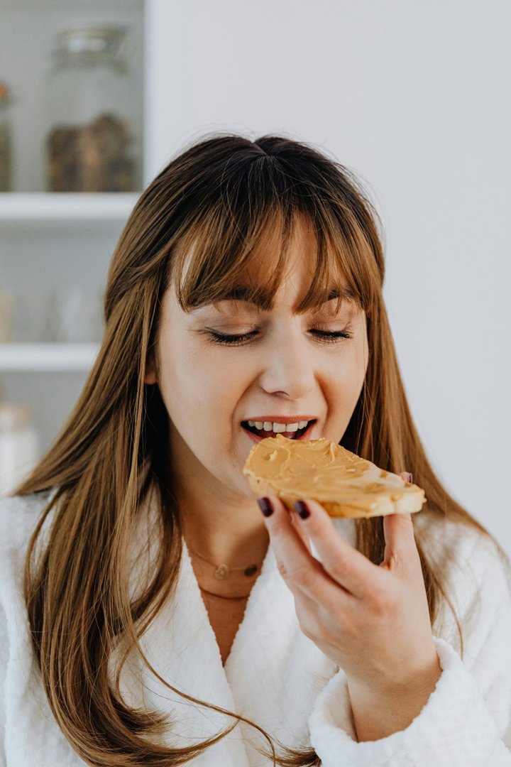 A woman eating a peanut butter sandwich | Source: Pexels