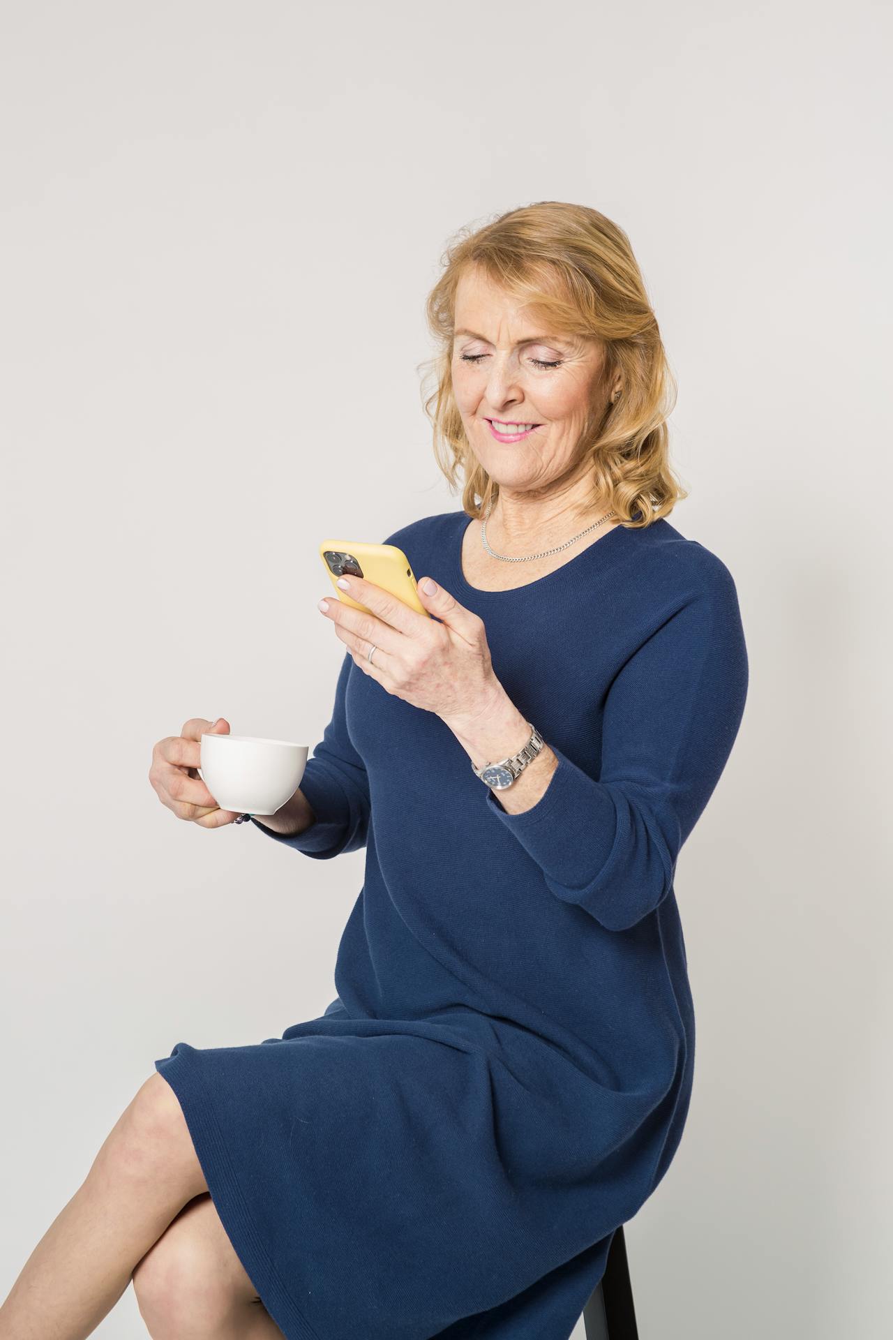 A smiling senior woman looking at her phone | Source: Pexels