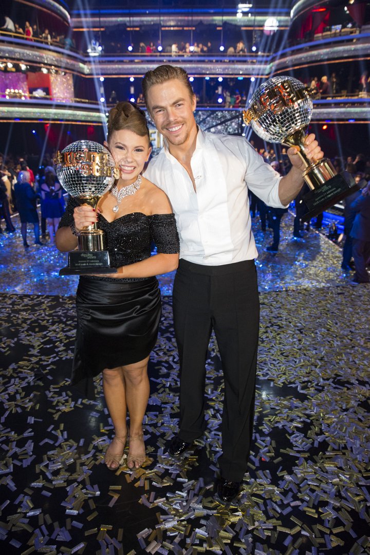Bindi Irwin and Derek Hough holding their mirror ball trophies after they won 