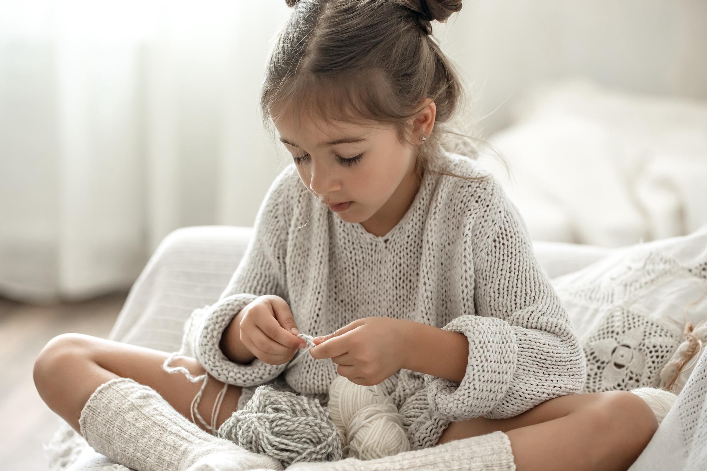 A little girl knitting | Source: Freepik