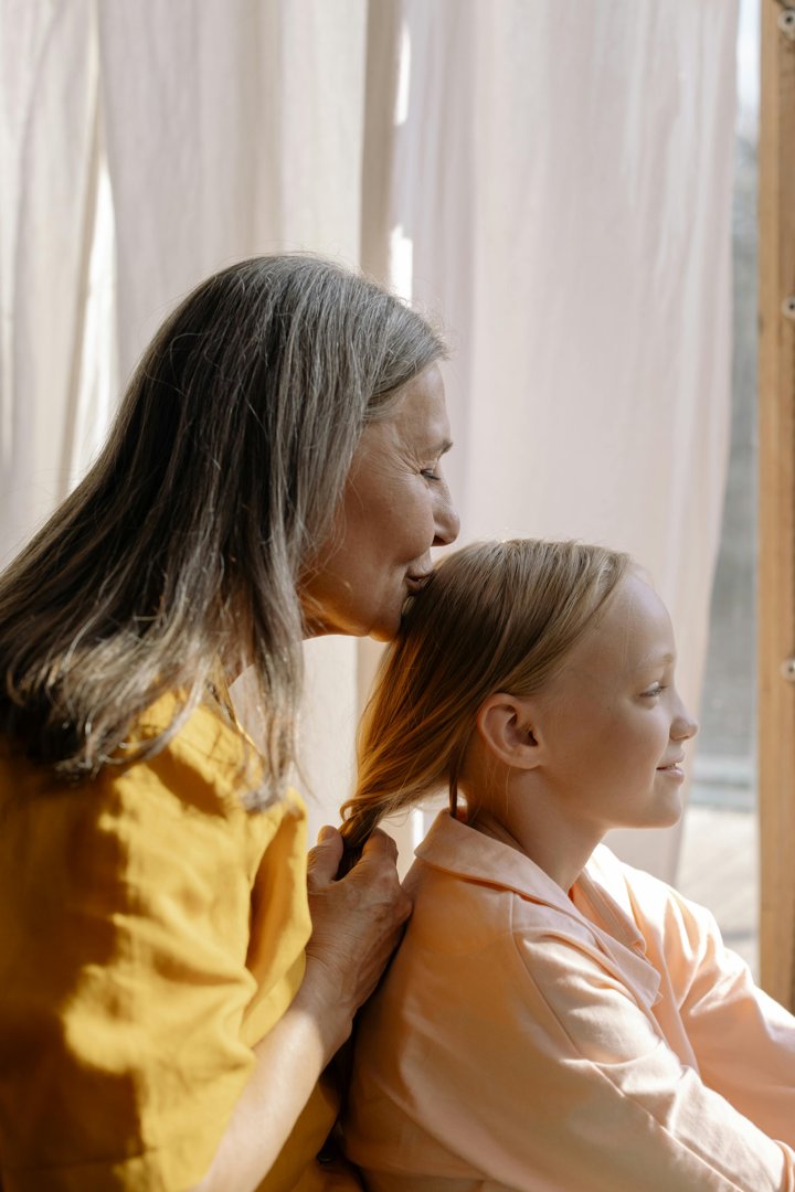 A grandmother kissing her granddaughter's head | Source: Pexels
