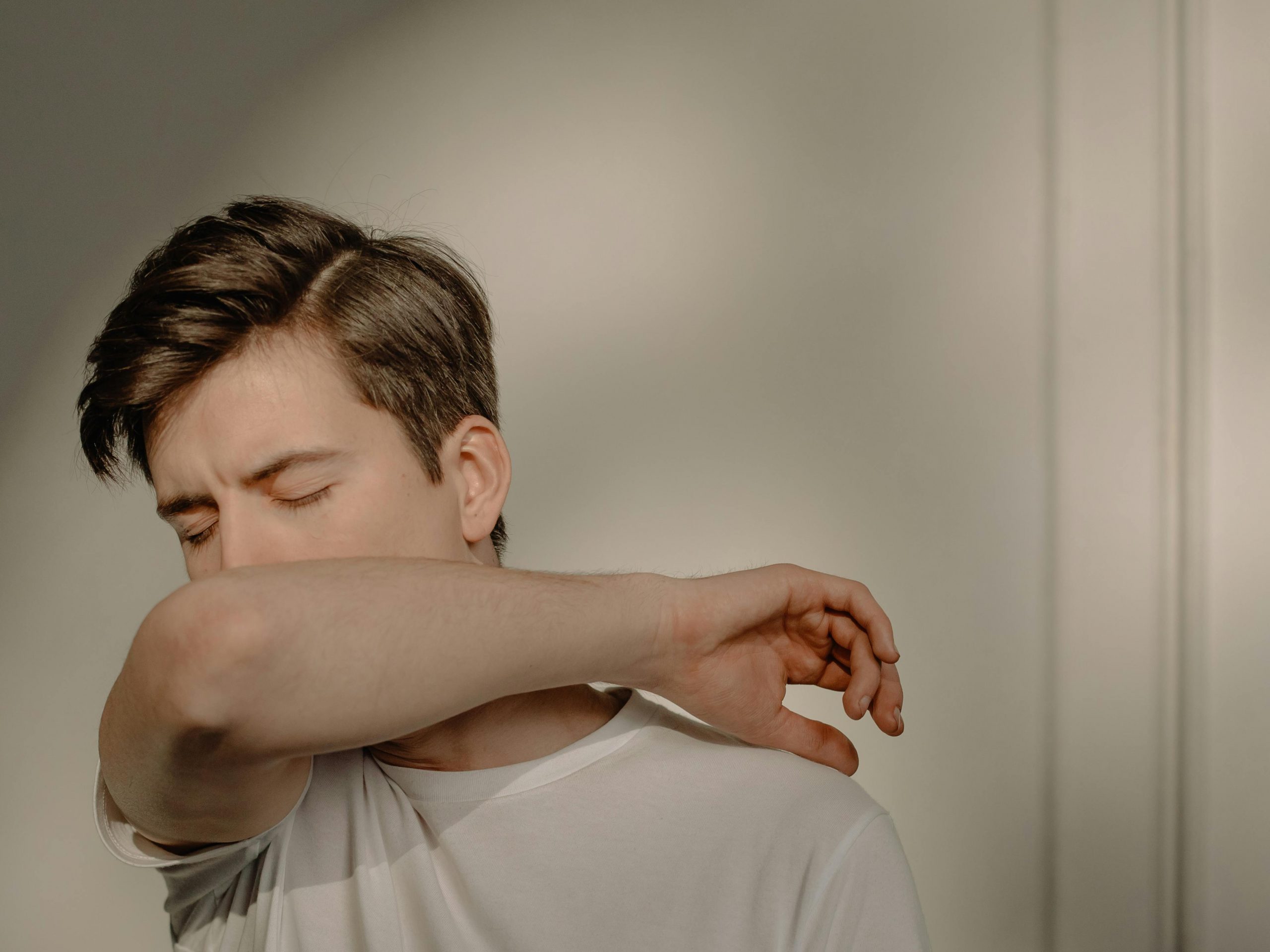 A man covering his mouth while coughing | Source: Pexels