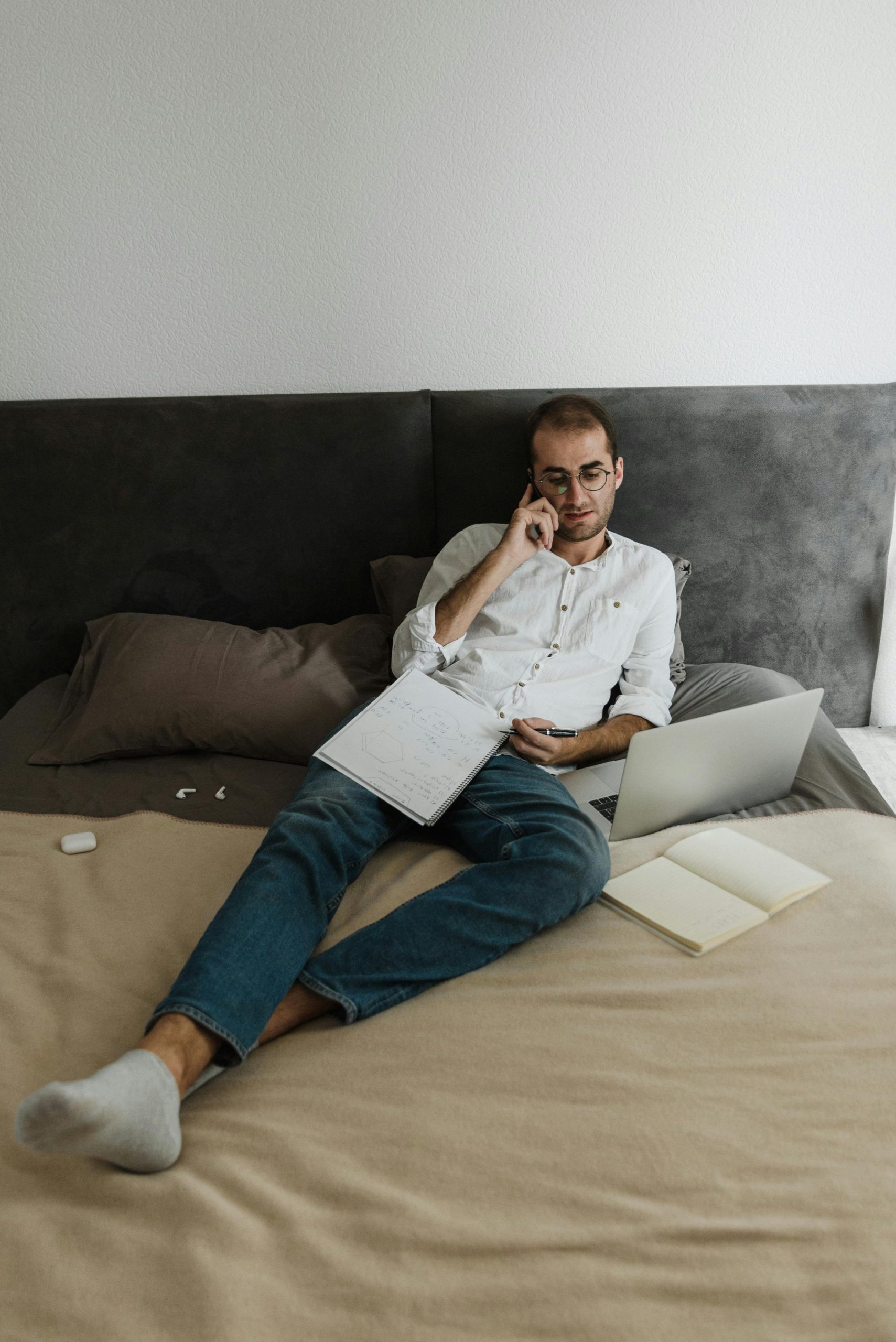 A man on a call while sitting on a bed | Source: Pexels