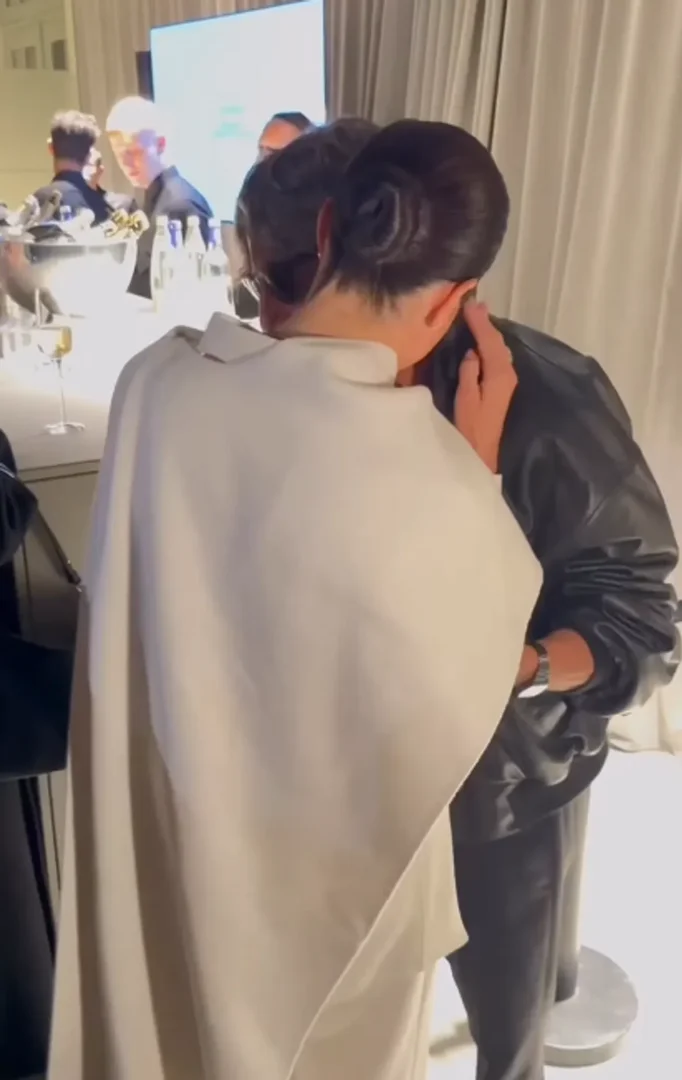 Meghan Markle whispers into Pierpaolo Piccioli's ear, continuing their conversation while touching each other's wrists. The gesture didn't sit well with many viewers. Source: Instagram/wwd