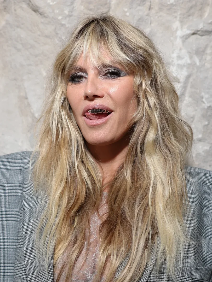 A much closer shot leaves no doubt that Heidi Klum is reveling in her silver grillz. They gleam under the lights, adding an extra edge to her daring look and revealing just how far the model is willing to go for an audacious statement.