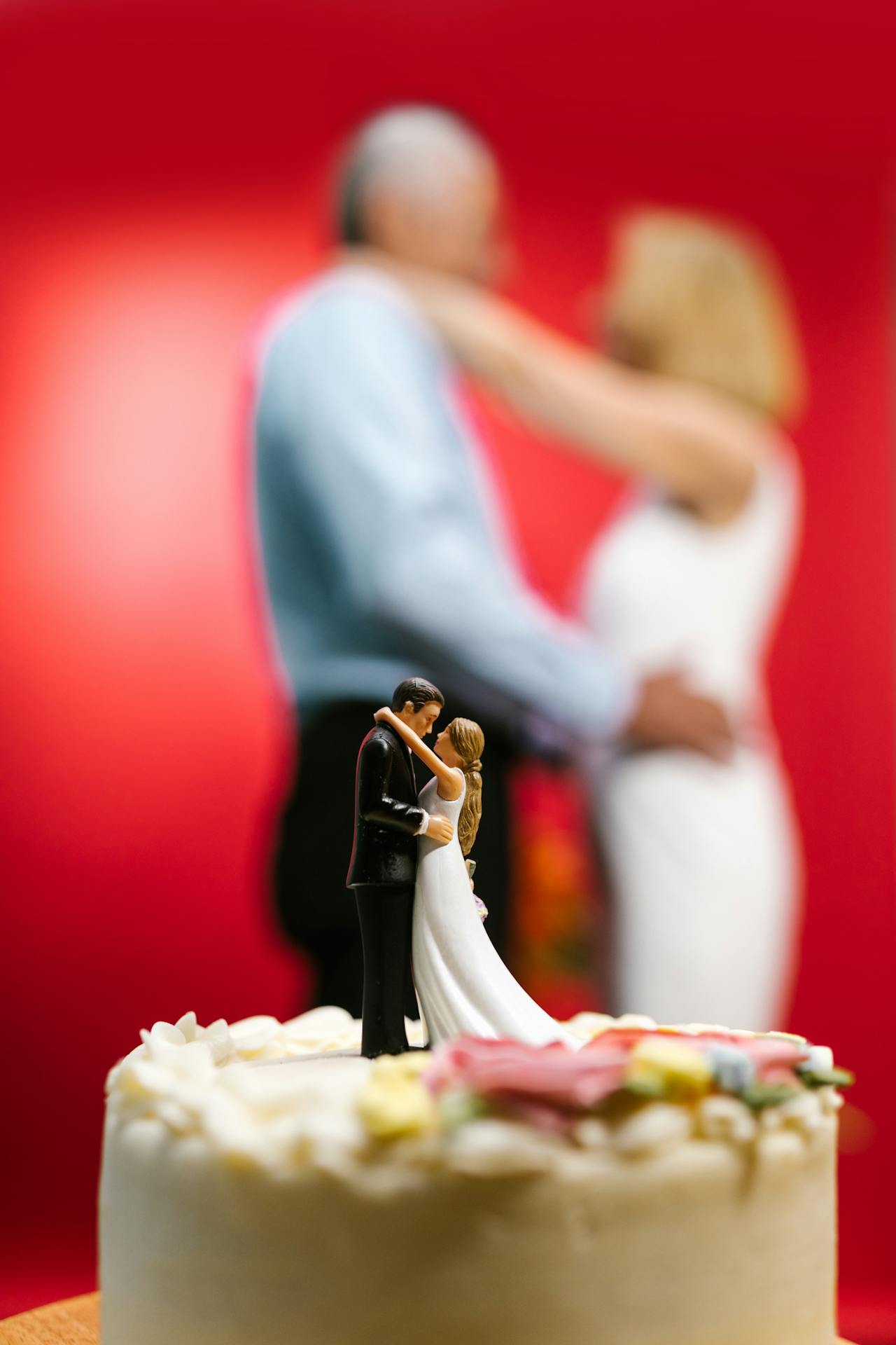A senior bride and groom standing behind their wedding cake | Source: Pexels