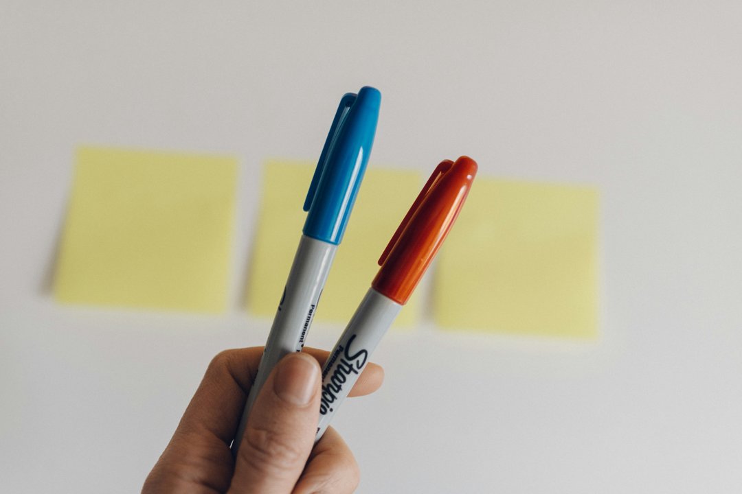 A person holding two Sharpie markers | Source: Unsplash