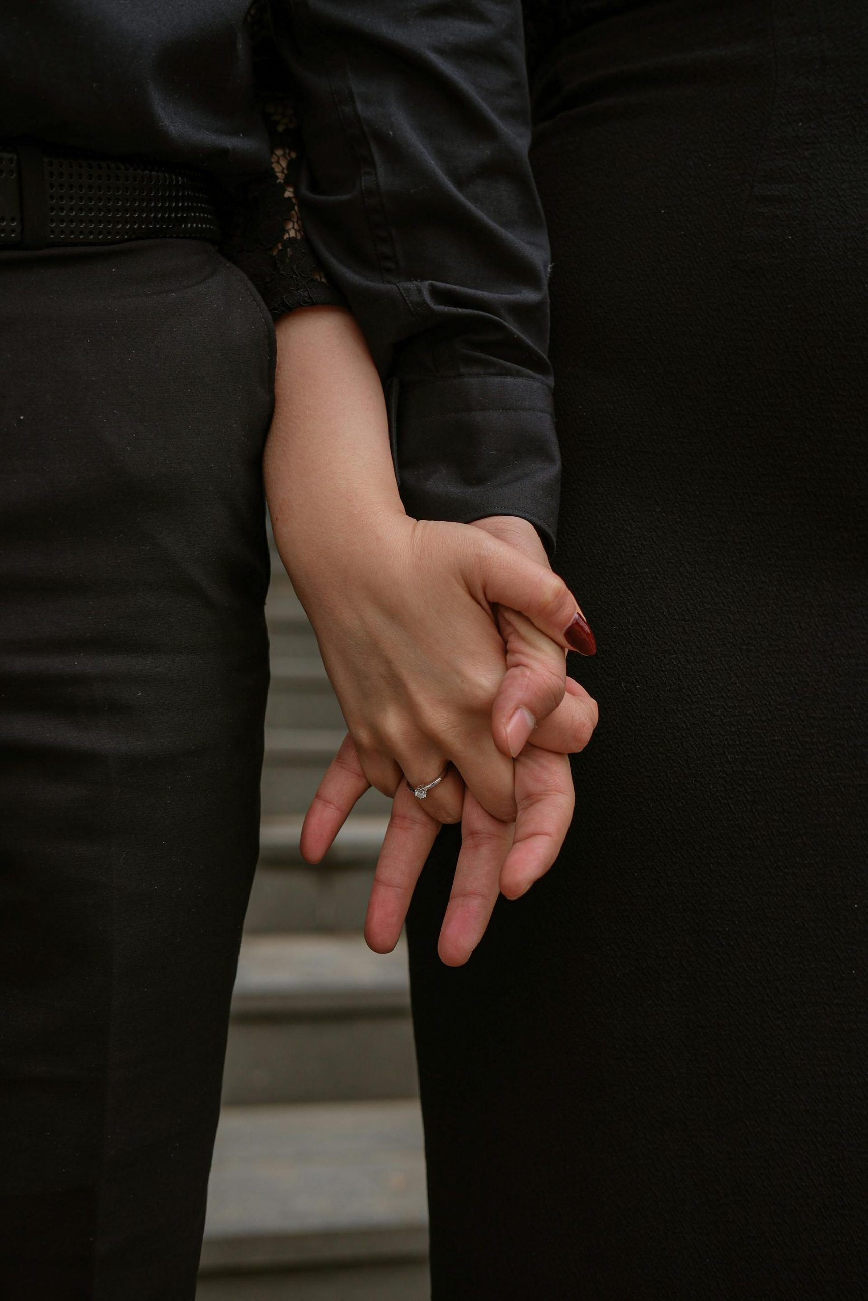 A couple holding hands on the steps of a building | Source: Pexels