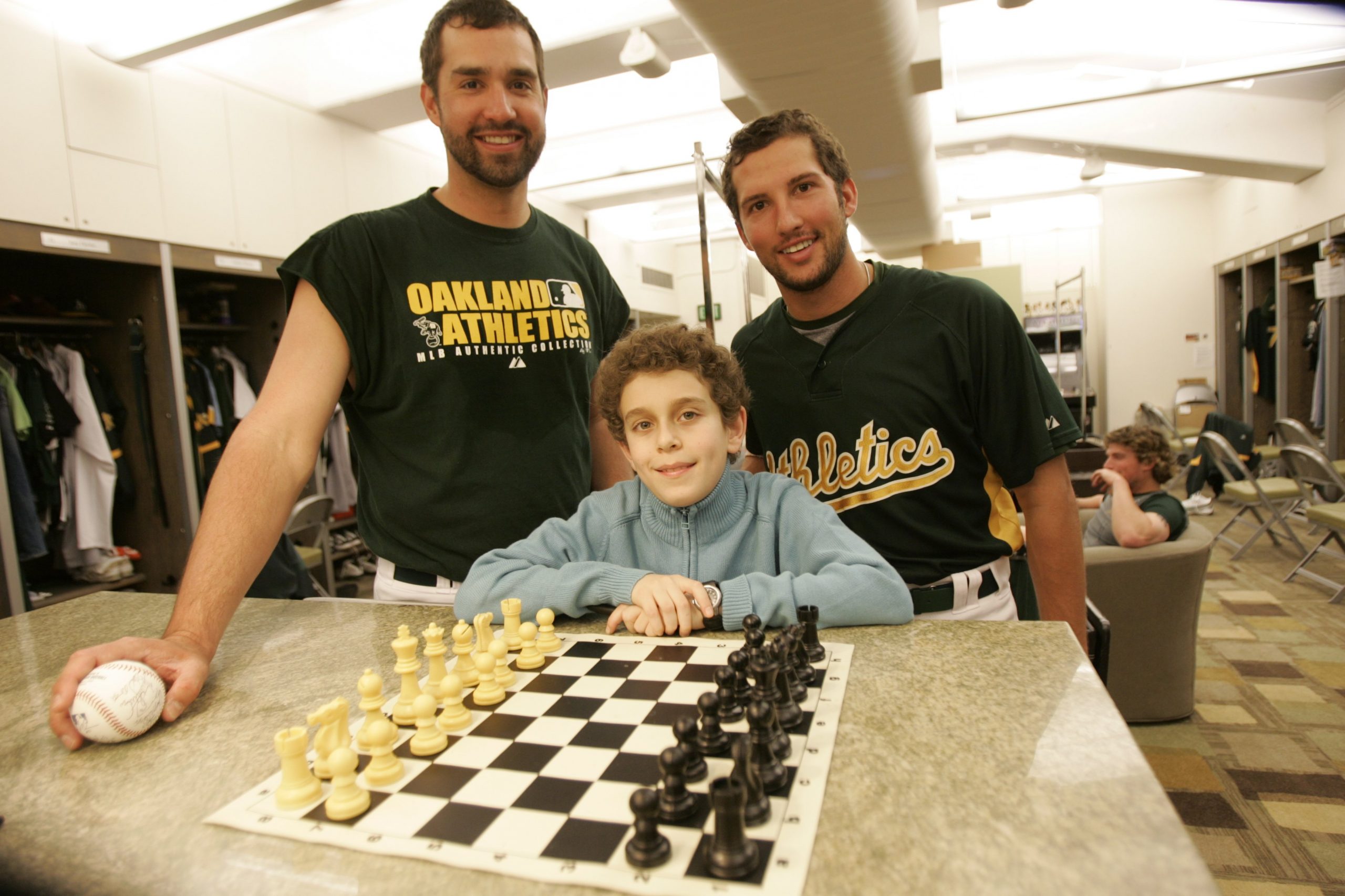 Chess champion Daniel Naroditsky meets Andrew Brown and Huston Street of the Oakland Athletics in the clubhouse in Oakland, California, on April 23, 2008 | Source: Getty Images