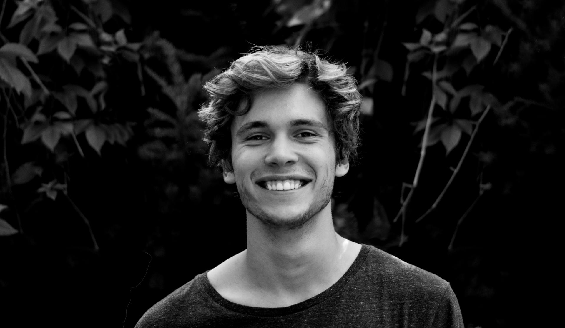 A grayscale photo of a smiling young man | Source: Pexels
