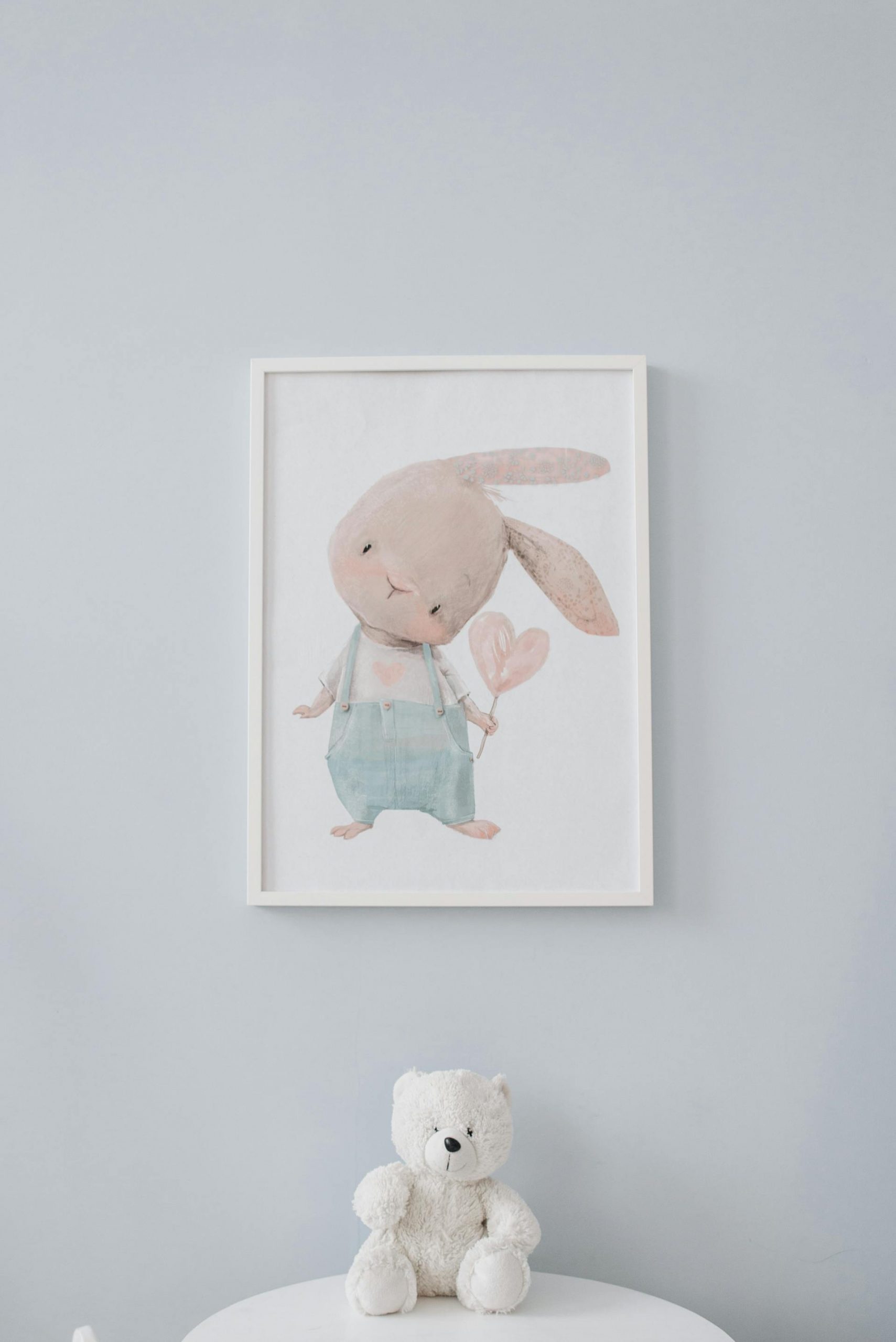 A stuffed teddy bear lying under a wall frame | Source: Pexels