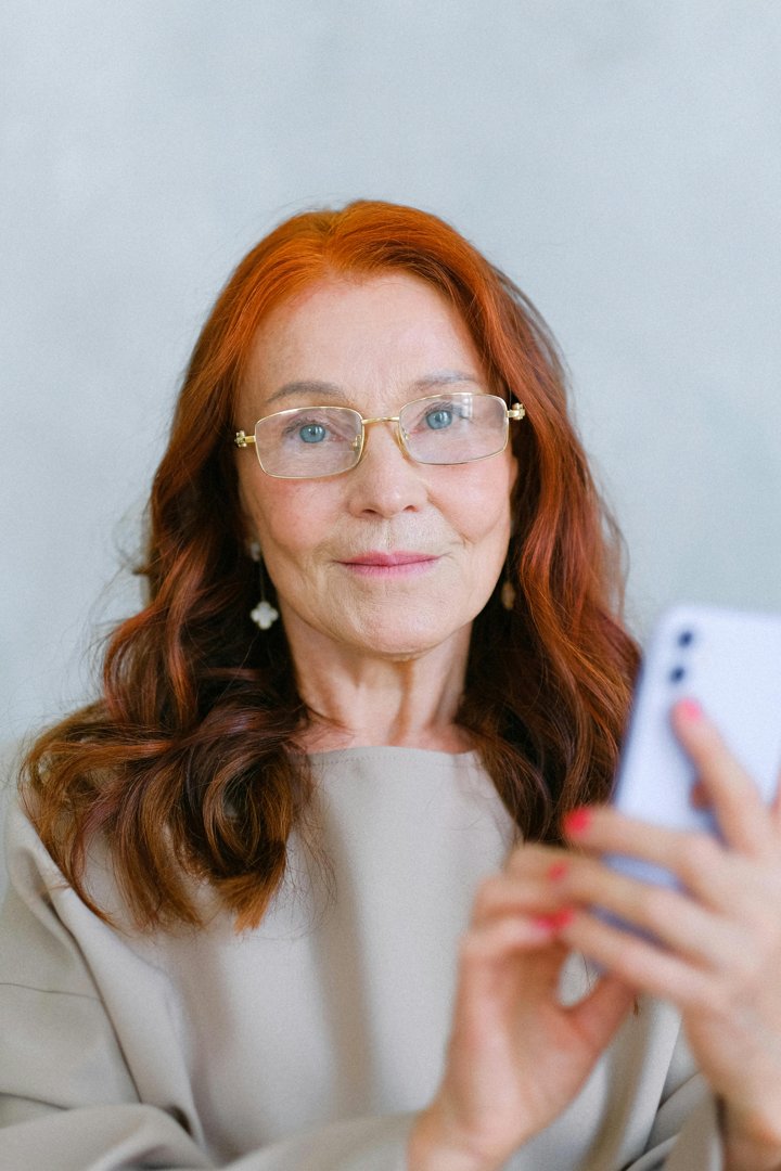 A happy woman using her phone | Source: Pexels