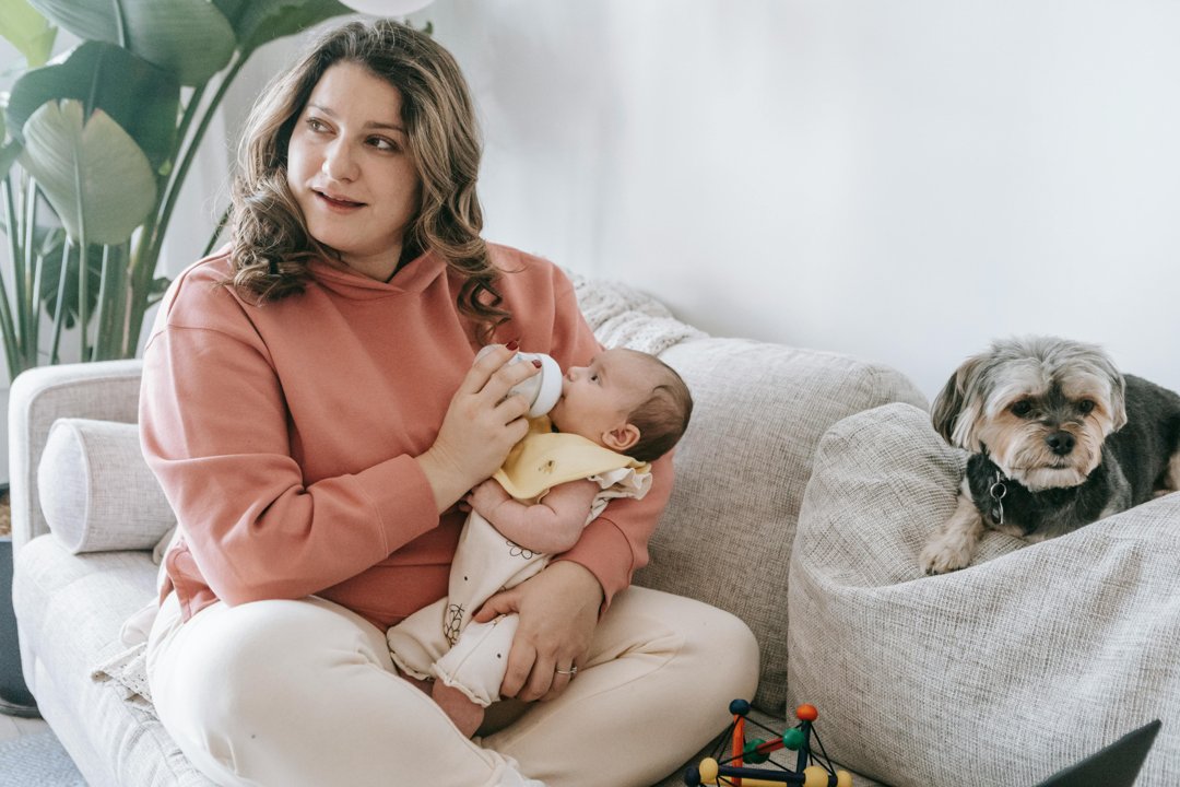A woman bottle-feeding a child | Source: Pexels