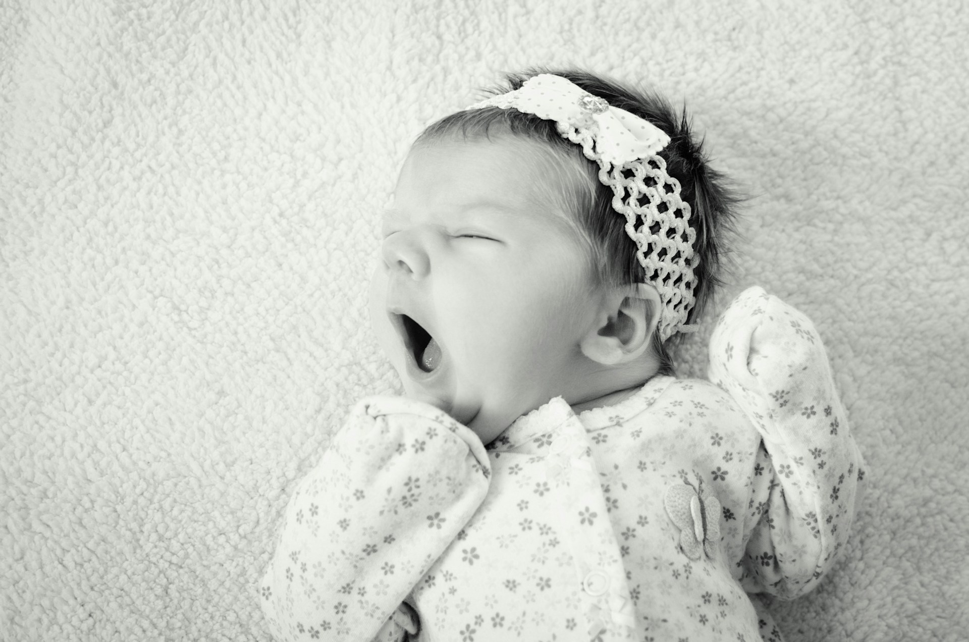 Grayscale shot of a newborn baby girl | Source: Unsplash
