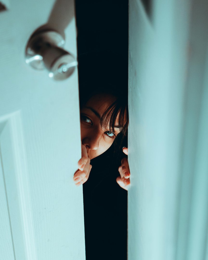 A woman peeking in through an open door | Source: Pexels