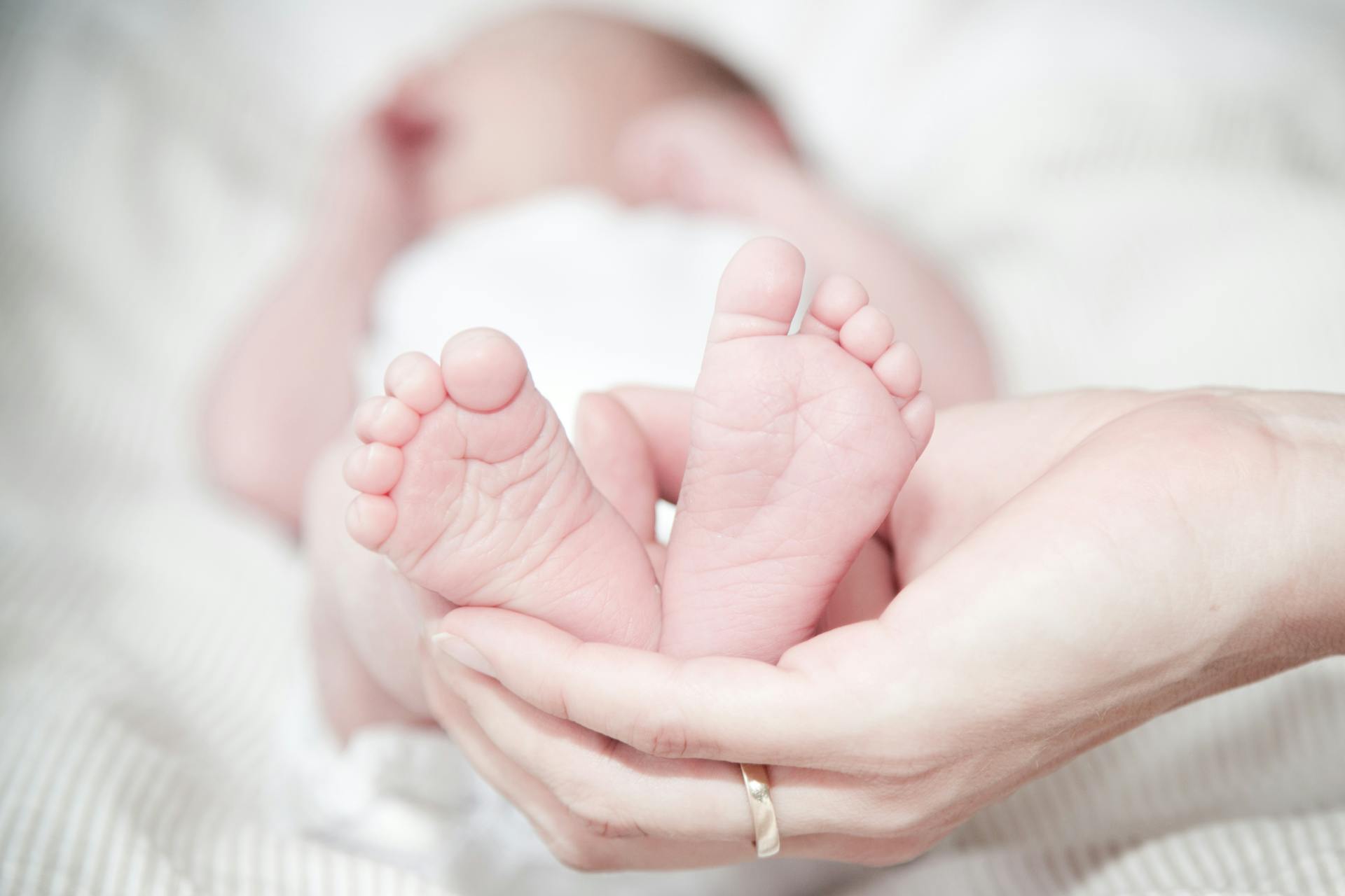 A woman holding a baby's feet | Source: Pexels