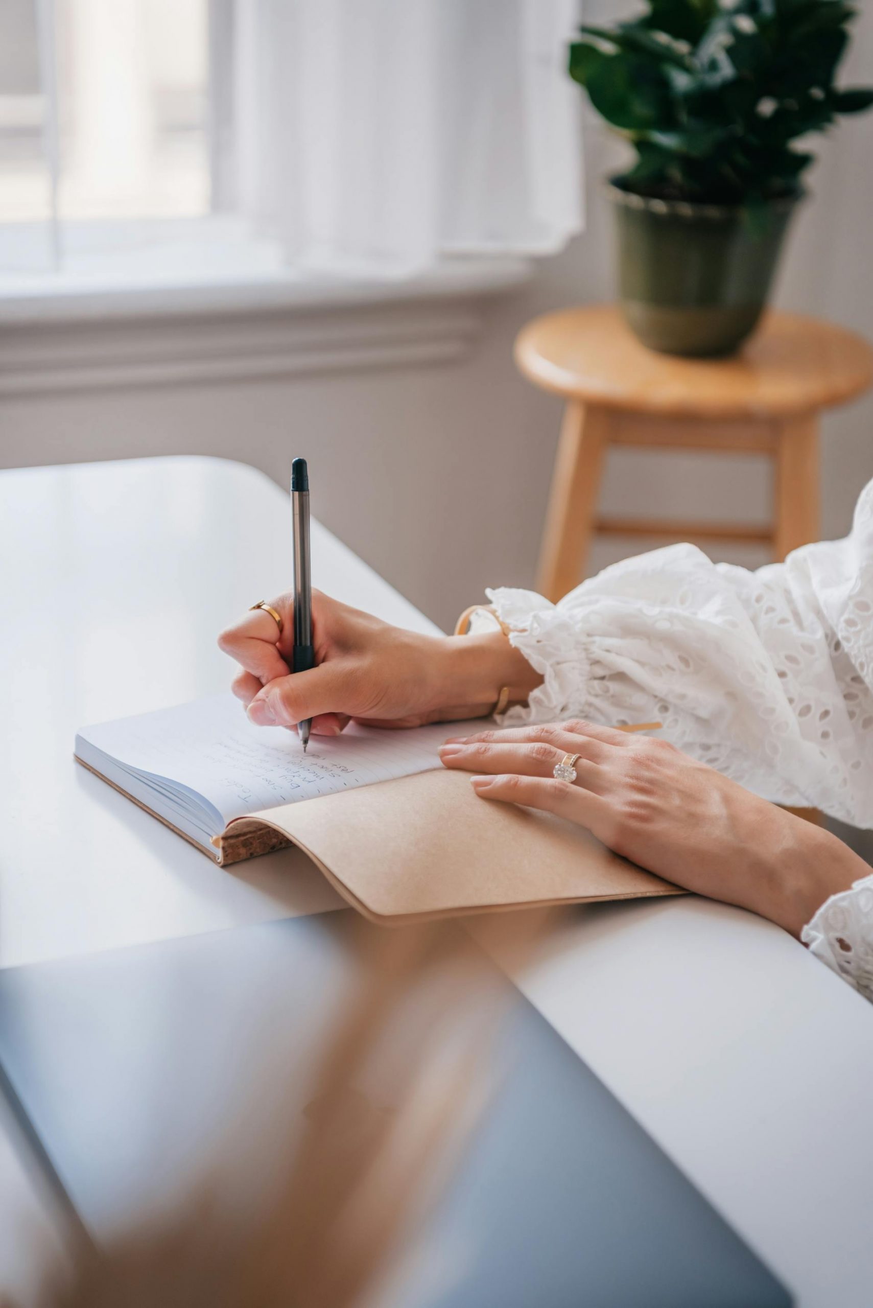 Woman writing on a notebook with a pen | Source: Pexels