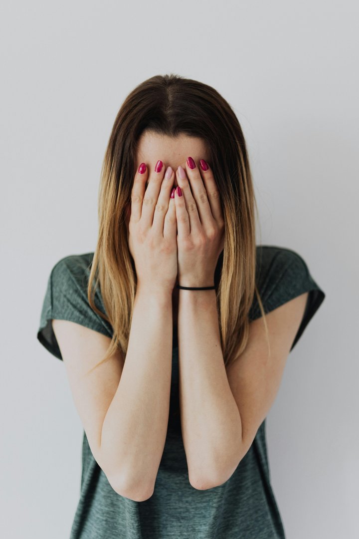A sad woman covering her face | Source: Pexels