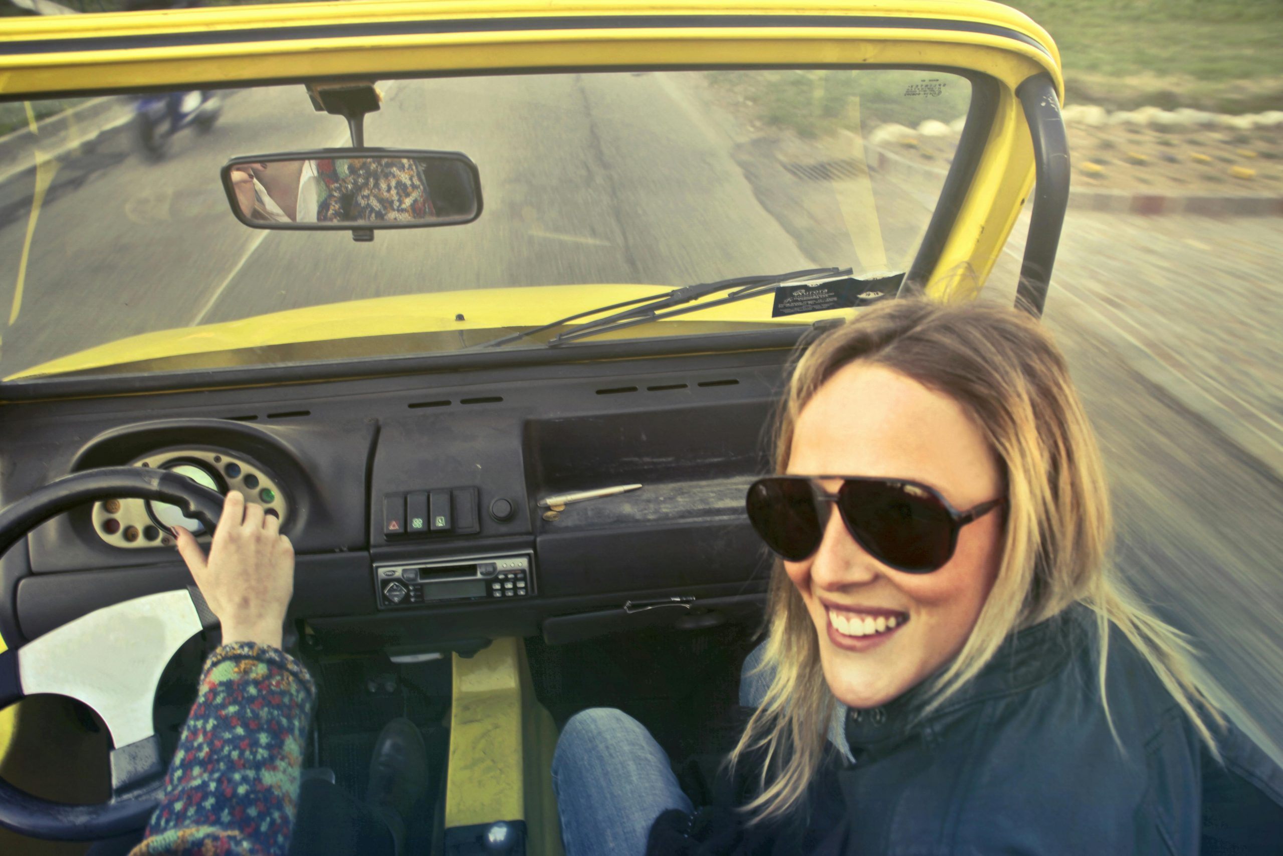 A woman laughing while seated in a car | Source: Pexels
