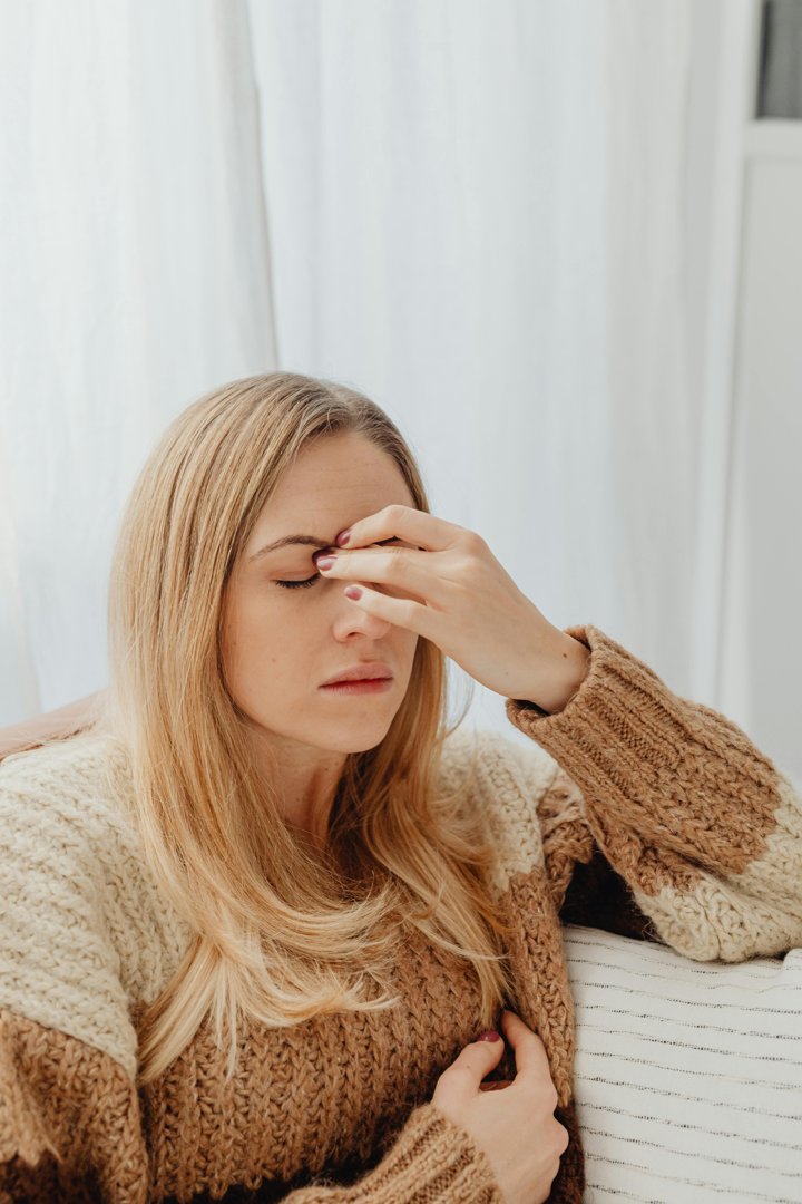 A woman holding the bridge of her nose | Source: Pexels