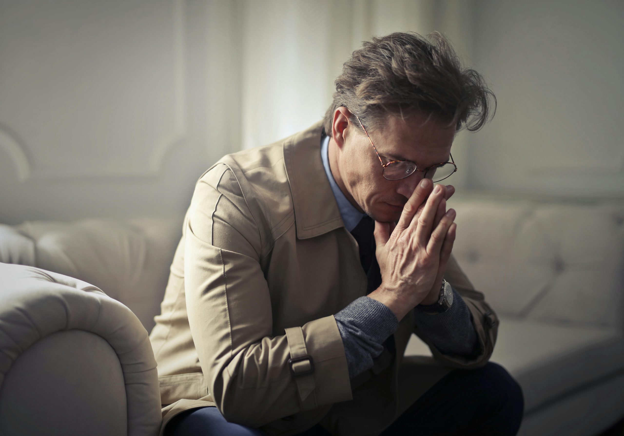 An upset man sitting on a couch | Source: Pexels
