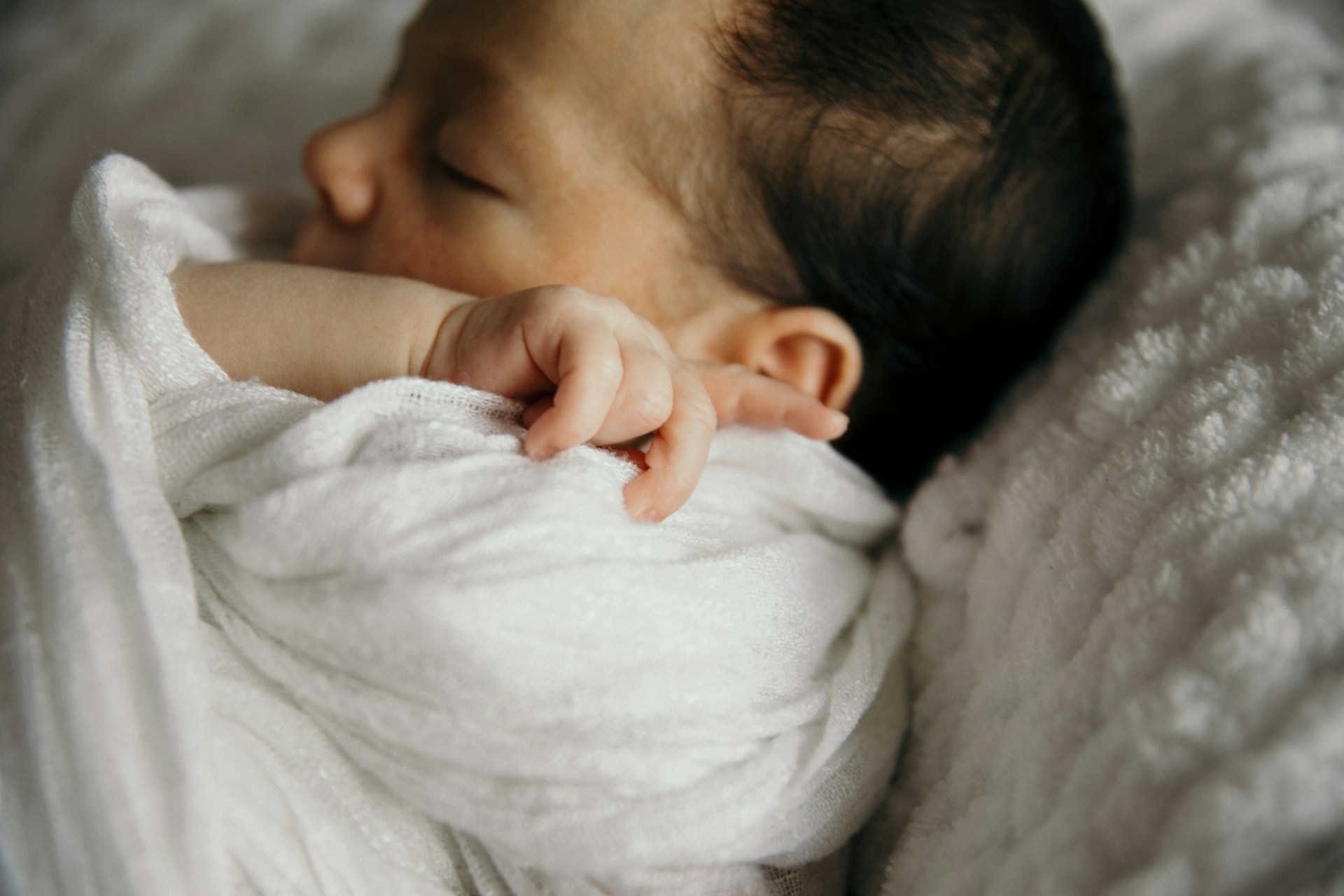 A newborn baby wrapped in a blanket | Source: Unsplash