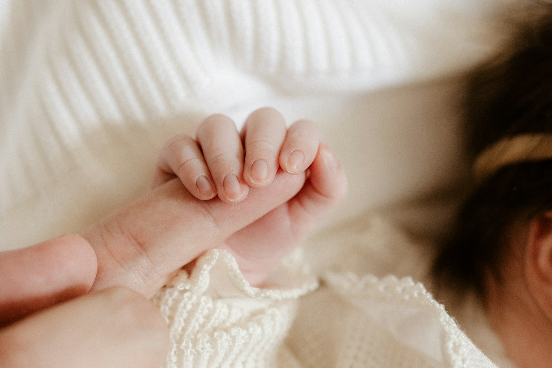 A baby holding a person's finger | Source: Unsplash