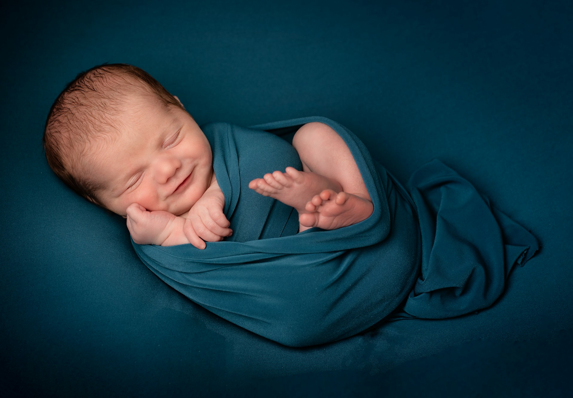 An adorable baby wrapped in a blue blanket | Source: Unsplash