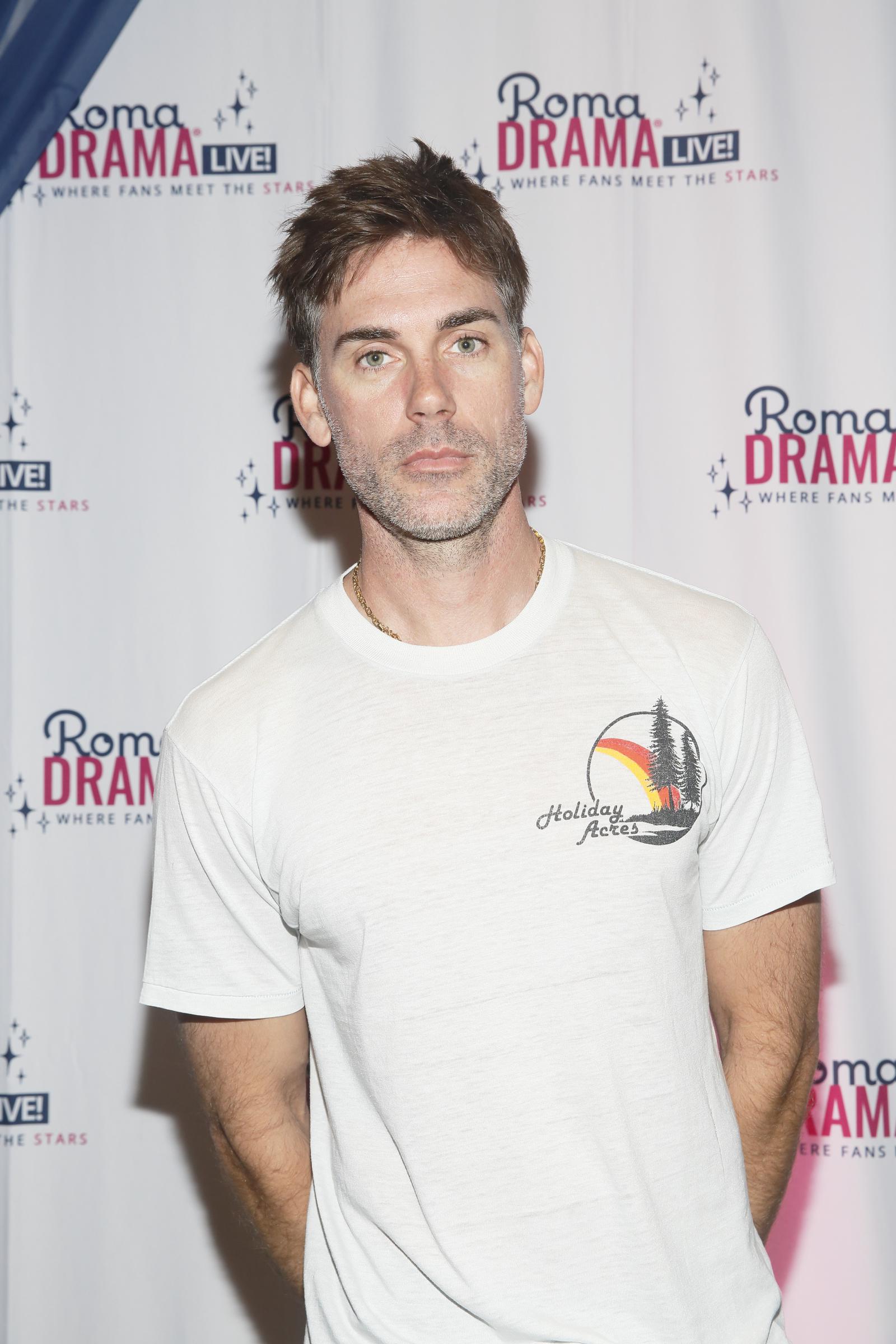Drew Fuller attends RomaDrama Live! in 2022, dressed casually in a white