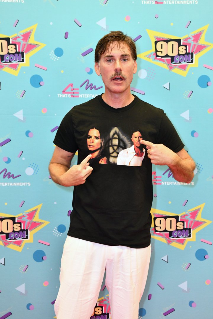Drew Fuller makes a playful appearance at 90s Con in 2024, pointing to a custom T-shirt featuring his
