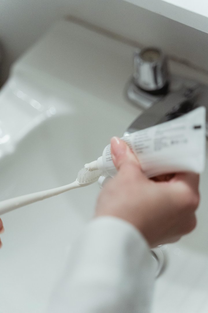 A person holding a toothbrush and a tube of toothpaste | Source: Pexels