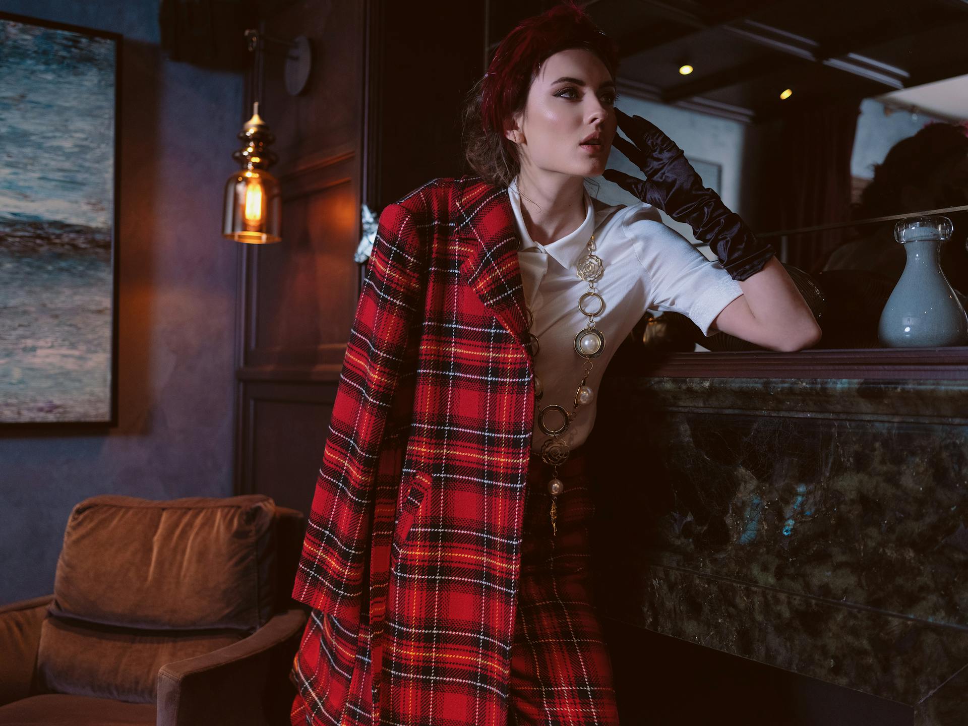A woman in a trendy red coat and matching pants looking at someone | Source: Pexels