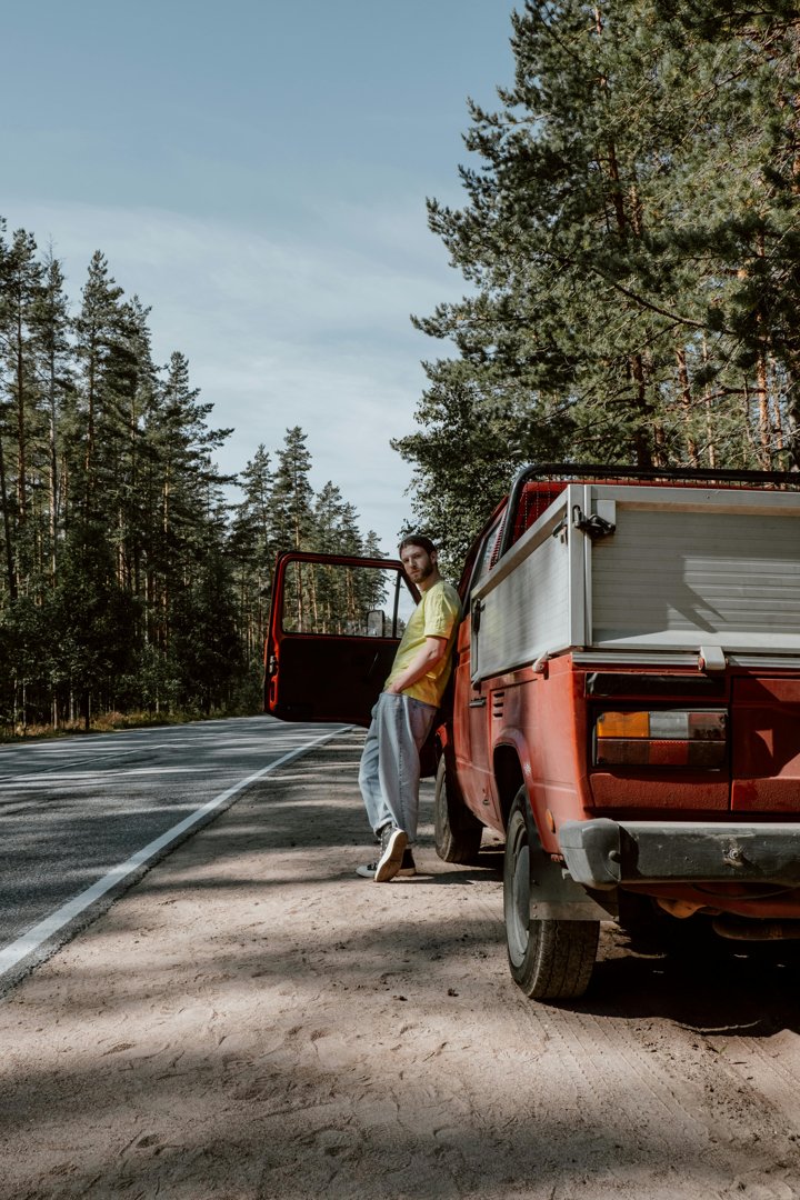A man leaning against a red pick-up truck | Source: Pexels
