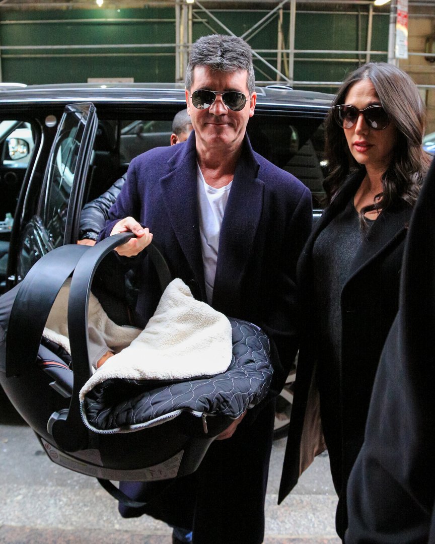 Simon Cowell and Lauren Silverman with their newborn son, Eric Cowell, arriving at their hotel on February 16, 2014, in New York | Source: Getty Images