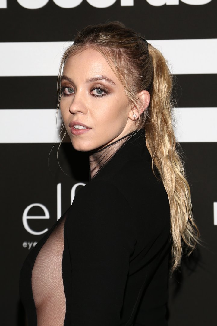 Wearing a dramatic smoky eye and her blond hair slicked back into a textured ponytail, Sydney Sweeney arrived at the Republic Records Grammy after-party exuding edgy elegance. Her black ensemble added a sleek contrast to the voluminous style.