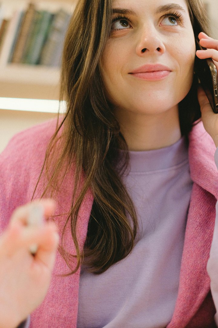 A woman with a faint smile on a call | Source: Pexels
