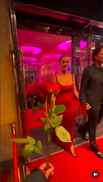 A fan holding out a rose for Katy Perry as she and Justin Trudeau make their way outside, posted on October 26, 2025. | Source: Instagram/tmz_tv