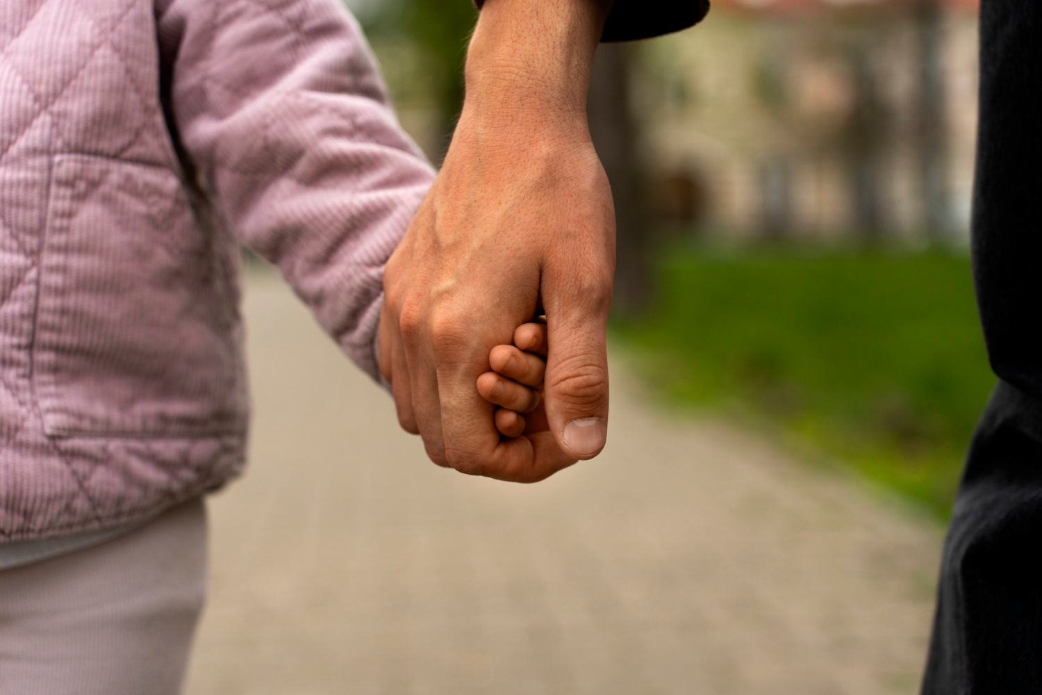 A person holding a child's hand | Source: Freepik