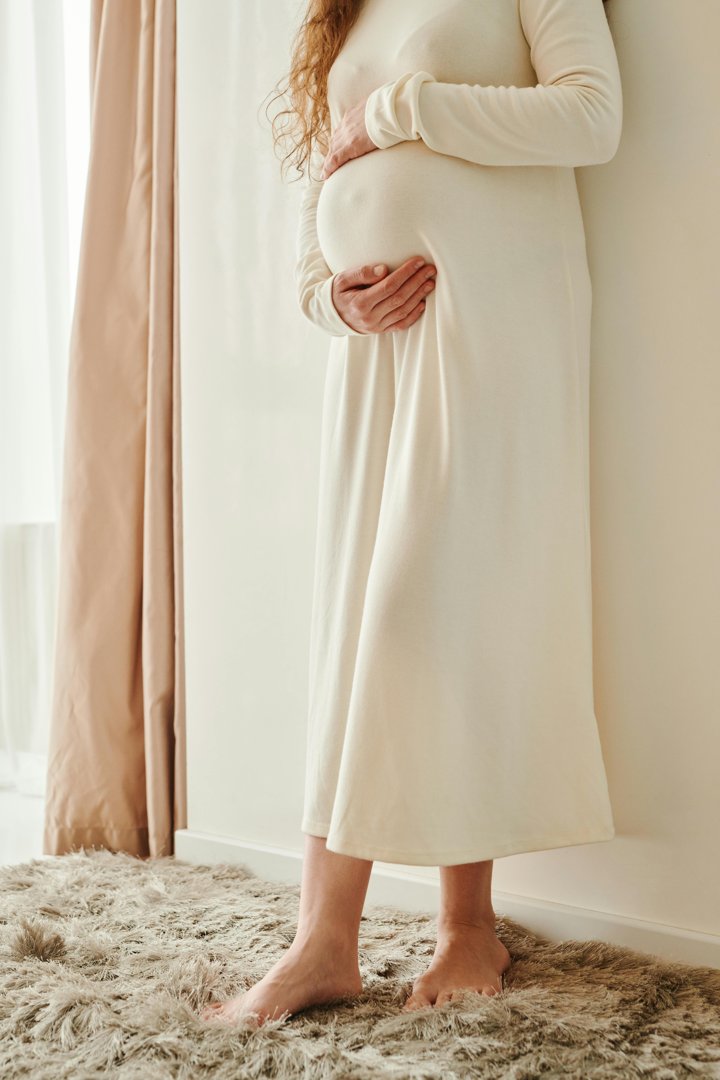 A pregnant woman cradling her tummy | Source: Pexels