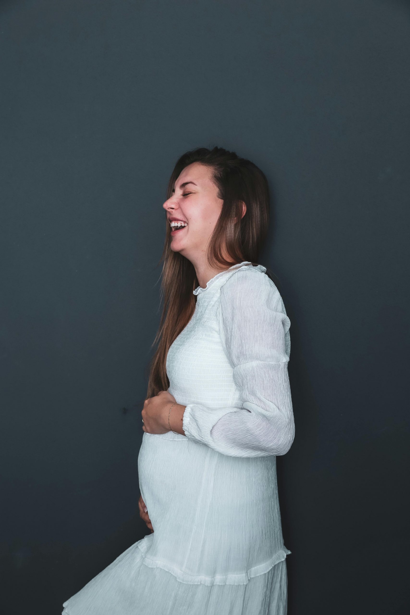 A pregnant woman laughing | Source: Pexels