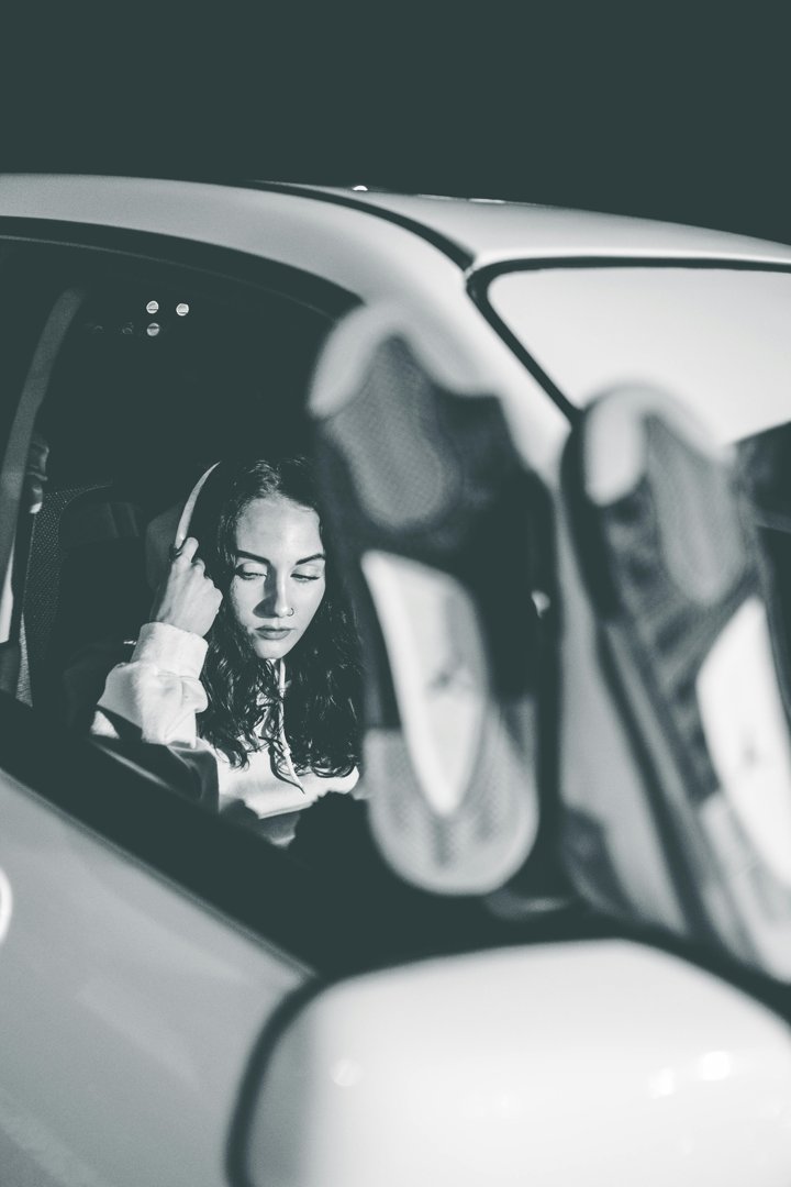 A serious woman sitting in the passenger's seat of a car | Source: Pexels